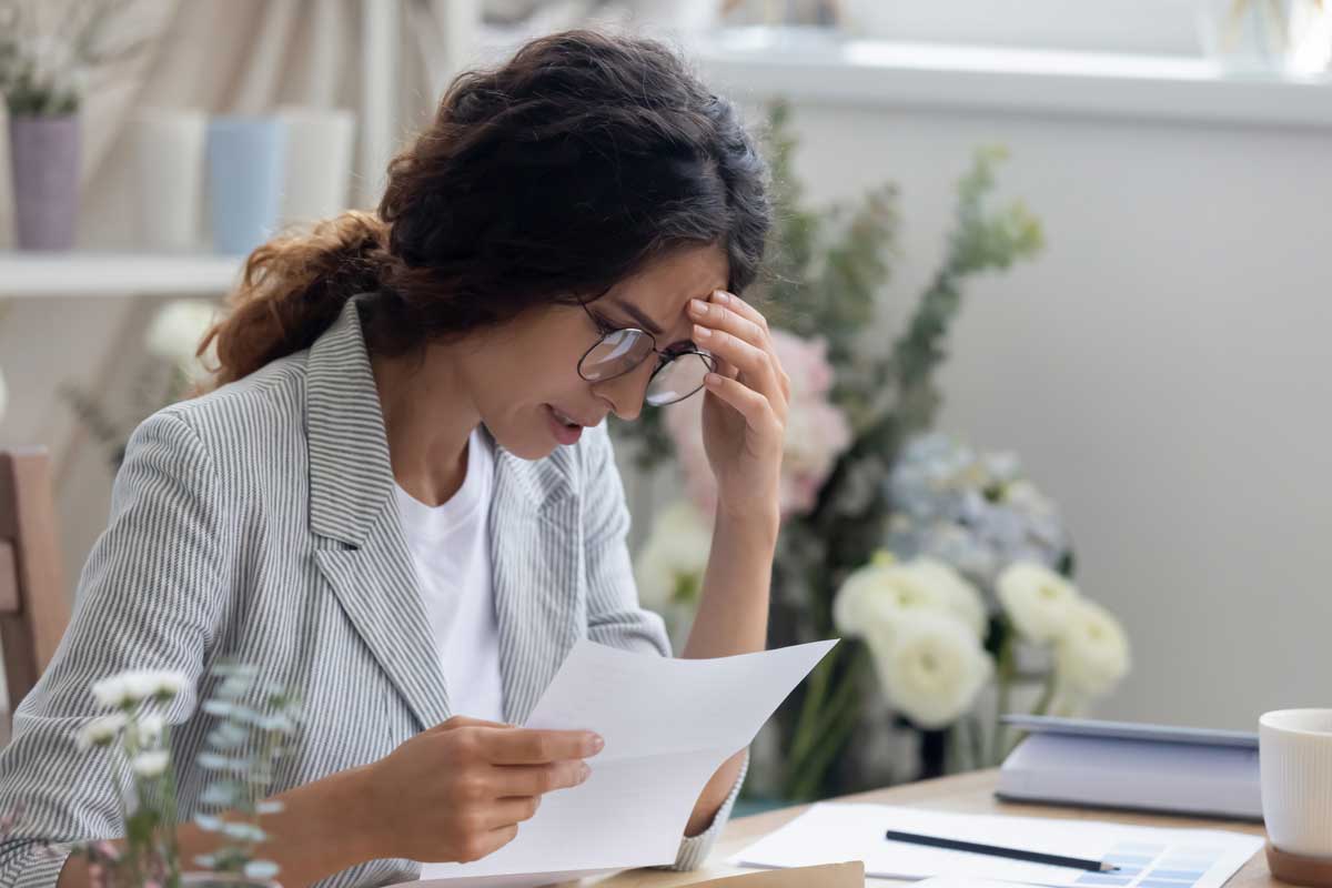 Head shot frustrated young businesswoman holding paper document.